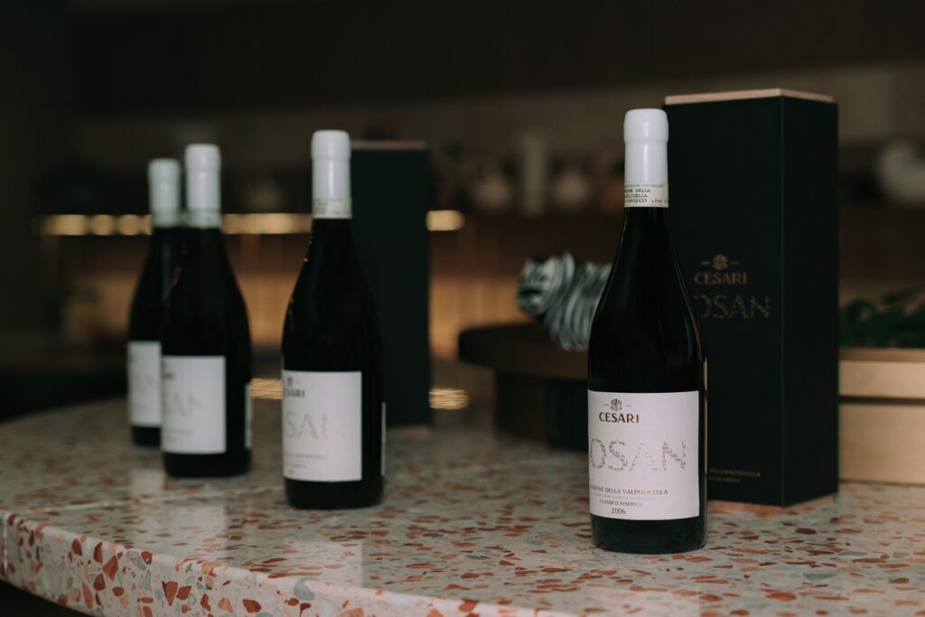 Bottles of Cesari Amarone della Valpolicella Riserva Bosan displayed on a red Venetian terrazzo counter for a vertical tasting event at BIVIUM Six Senses Rome.