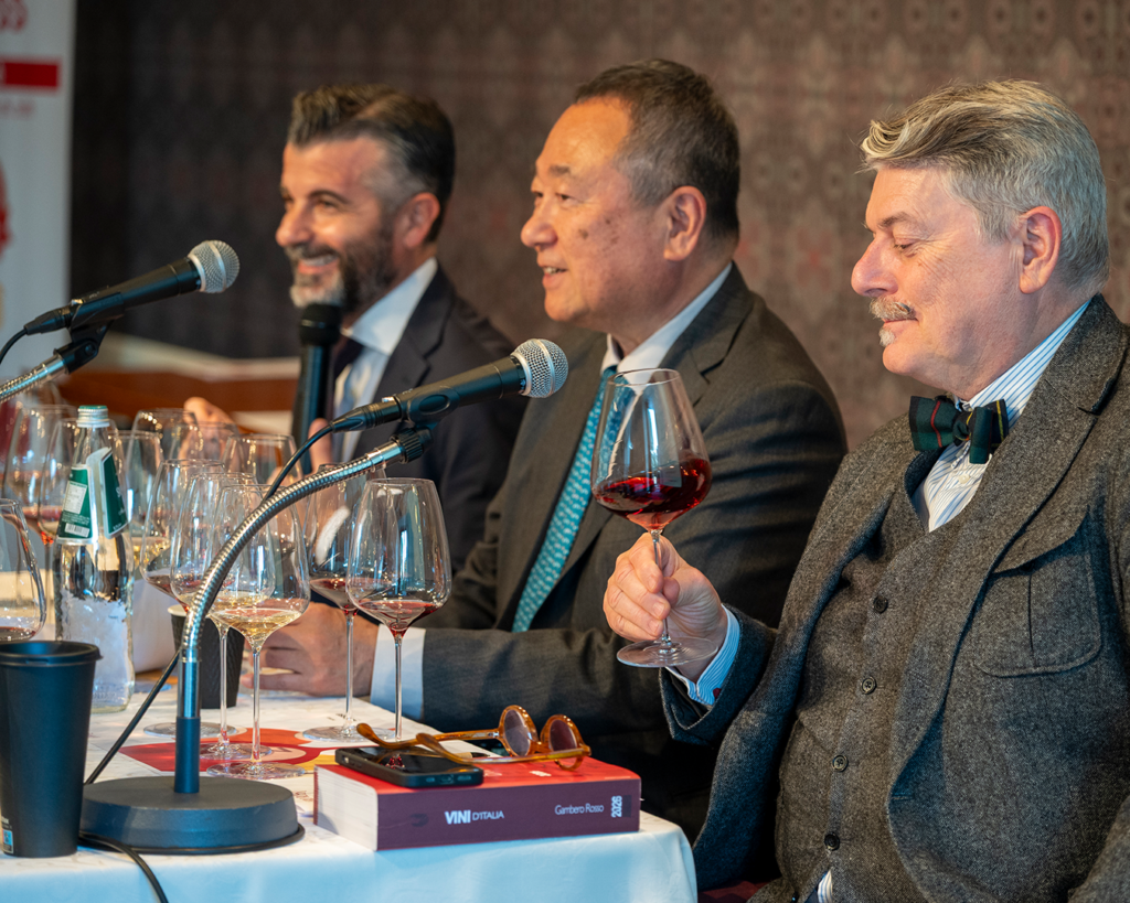 Three wine experts or sommeliers leading a wine masterclass with glasses in front of them and microphones