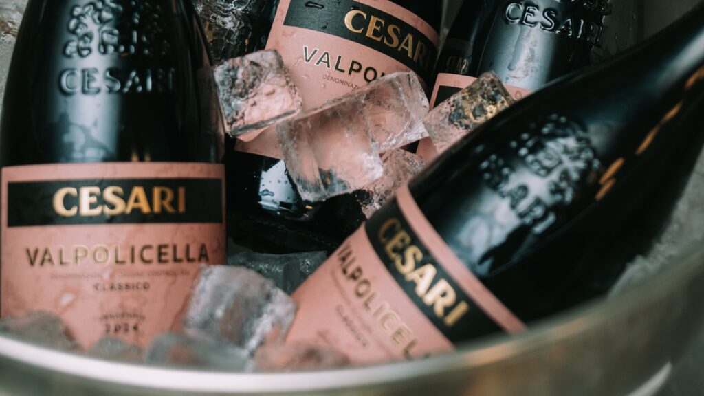 Valpolicella Classico freddo _Valpolicella Classico chilled_close up of Pink labelled bottles of red wine Valpolicella Classico Cesari set inside an ice bucket