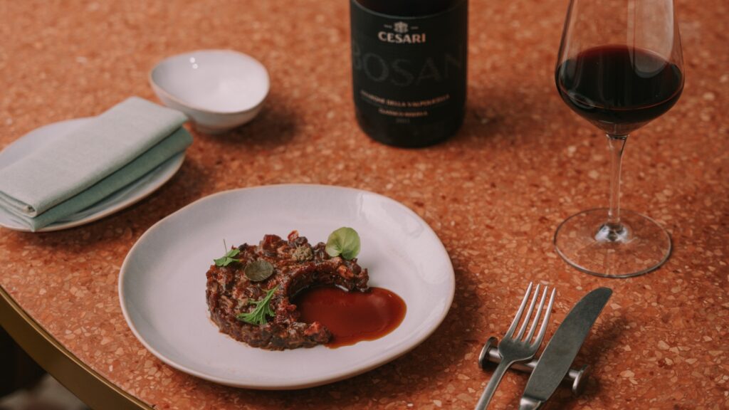 abbinamenti Amarone_picture of a bottle of amarone riserva Bosan Cesari beside a gourmet tartare